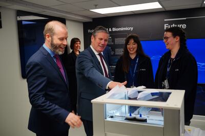 Keir Starmer, second left, and shadow business secretary Jonathan Reynolds, left, are shown a paper-plane launching device made by apprentices in the Stem academy, during a visit to Airbus in Bristol. PA