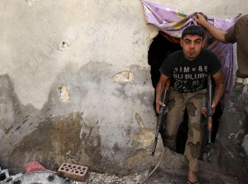 A Free Syrian Army fighter carrying his weapons walks out from a hole in a wall in Aleppo's Karm al-Jabal district, June 2, 2013. REUTERS/Muzaffar Salman SYRIA (CIVIL UNREST) *** Local Caption ***  SYR13_SYRIA-CRISIS-_0602_11.JPG