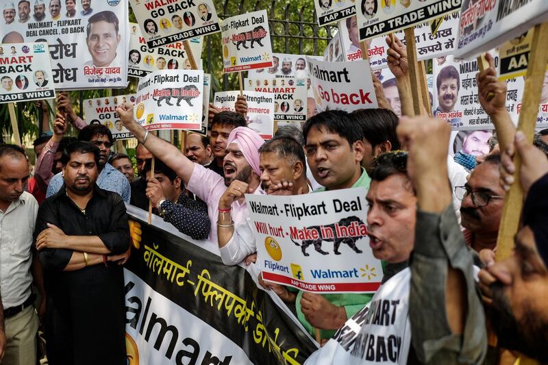 (FILES) In this file photo taken on May 12, 2018 Indian protesters take part in a demonstration against a deal between US retail giant Walmart and Indian online sales company Flipkart in New Delhi. India's commerce ministry has announced it will tighten e-commerce rules affecting Indian online sales leader Flipkart -- recently acquired by US retail giant Walmart -- and US rival Amazon from selling goods from companies in which they hold an equity stake. / AFP / CHANDAN KHANNA
