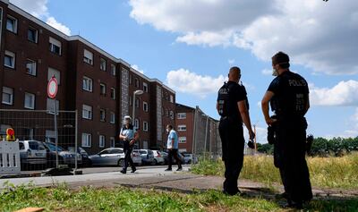 Police officers stand at the residential homes of employees of the abattoir company Toennies during their quarantine in the district Suerenheide of Verl on June 22, 2020.

 The company stopped its production after more than a thousand of employees were tested positive on the novel coronavirus. The German government banned the use of subcontractors in the meat industry after a string of coronavirus infections among mainly foreign slaughterhouse workers sparked alarm already in May 2020. "It's time to clean up the sector," Labour Minister Hubertus Heil said. From January 1, 2021 abattoirs and meat processing plants will have to directly employ their workers, putting an end to the controversial practice of relying on chains of subcontractors to supply labourers from abroad, often from Bulgaria and Romania. / AFP / Ina FASSBENDER
