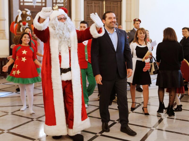 Lebanese Prime Minister Saad al Hariri is seen with a man dressed as Santa Claus during Christmas celebrations with orphaned children in Beirut, Lebanon December 23, 2017. REUTERS/Mohamed Azakir