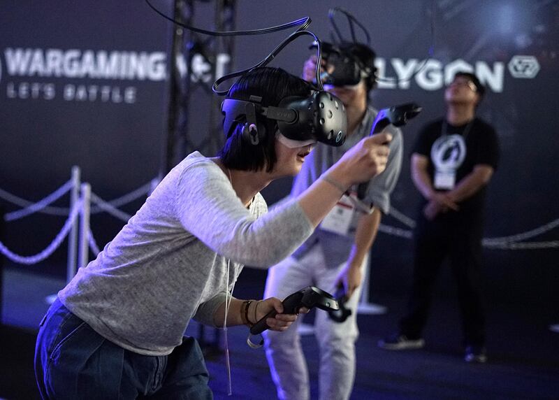 Visitors try out a game with a virtual reality headset device at the Tokyo Game Show in Chiba. Eugene Hoshiko / AP Photo