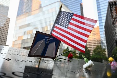 An American flag placed along with a photo of the Twin Towers and the name Daniel P.  Trant, a Cantor Fitzgerald bond trader that died during 9/11, at a ceremony at Ground Zero held in commemoration of the 20th anniversary of the terrorist attacks on the World Trade Center, the Pentagon and the crash of United Airlines Flight 93 in Shanksville, PA, held in lower Manhattan, New York City,on September 11, 2021.  (Photo by Anthony Behar  /  POOL  /  AFP)