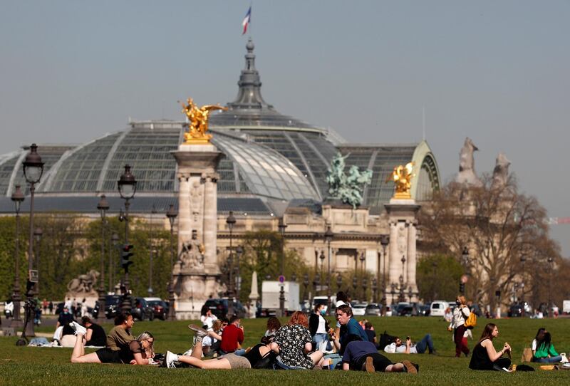 People enjoy warm weather near the Invalides in Paris. Reuters