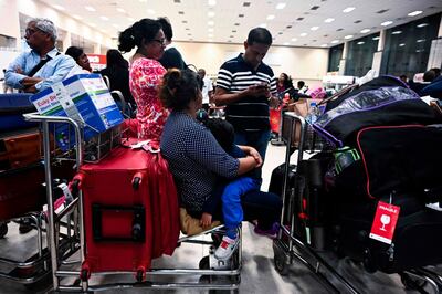 Passengers wait inside the arrival hall at Bandaranaike International Airport in Katunayake on April 22, 2019, after authorities imposed a curfew following eight bomb blasts in the country. A series of eight devastating bomb blasts ripped through high-end hotels and churches holding Easter services in Sri Lanka on April 21, killing at least 207 people, including dozens of foreigners. / AFP / Jewel SAMAD
