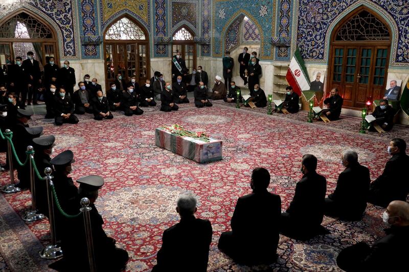 In this picture released by the Iranian Defense Ministry and taken on Saturday, Nov. 28, 2020, people pray over the flag draped coffin of Mohsen Fakhrizadeh, an Iranian scientist linked to the country's disbanded military nuclear program, who was killed on Friday, during a funeral ceremony at the Imam Reza holy shrine in the northeastern city of Mashhad, Iran. An opinion piece published by a hard-line Iranian newspaper has suggested that Iran must attack the Israeli port city of Haifa if Israel carried out the killing of a scientist. (Iranian Defense Ministry via AP)