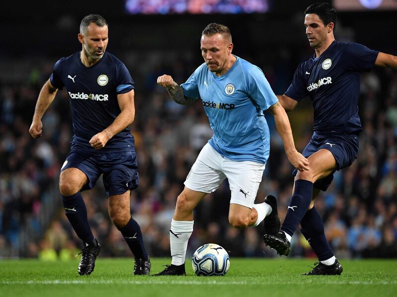 Premier League All-stars XI's Ryan Giggs and Mikel Arteta vie with Manchester City Legend's Welsh forward Craig Bellamy. AFP