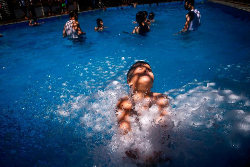 Palestinian youths play in a pool in Gaza city. AFP