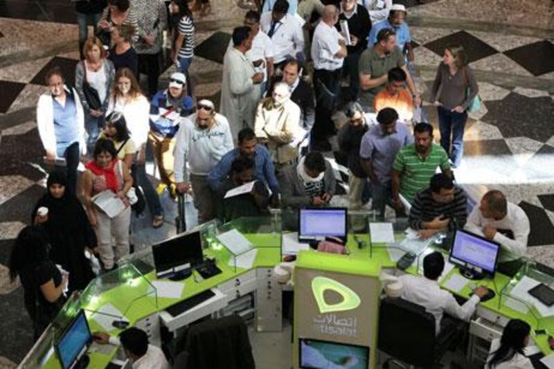 
DUBAI , UNITED ARAB EMIRATES  –  Jan 15 : People standing in a queue to re - register their mobile SIM cards at the Etisalat outlet in Mall of the Emirates in Dubai. ( Pawan Singh / The National ) For News. Story by Nadeem
