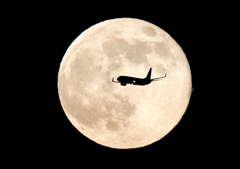 epa03757290 An airplane flies past the supermoon near Madrid, Spain, 24 June 2013. The 'supermoon' filled the sky on 23 June and looked 14 per cent bigger and 30 per cent brighter than normal, which is the closest approach to Earth.  EPA/CHEMA MOYA *** Local Caption ***  03757290.jpg