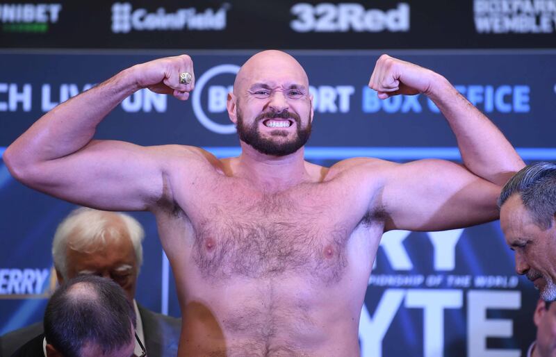 Tyson Fury poses on the scales. EPA