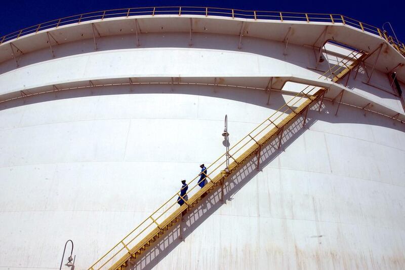 Oil technicians climb down a giant tank at a refinery in Jebel Ali. Kamran Jebreili / AP Photo