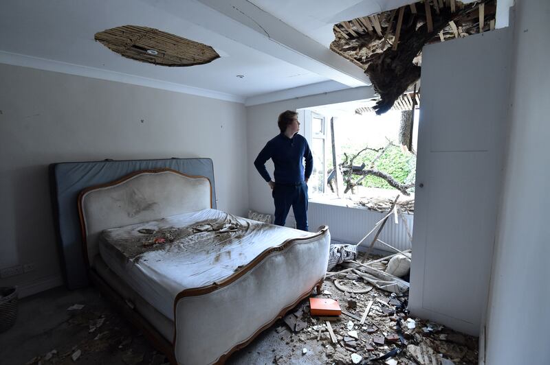 Sven Good, 23, looks at the damage caused to his bedroom at his family home in Stondon Massey, near Brentwood, Essex, after a 400-year-old oak tree in the garden was uprooted by Storm Eunice. PA