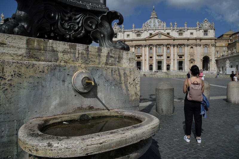 A woman looks the St. Peter Basilica near at a fountain that has been switched off in St Peter's Square, in Vatican city, after the Vatican authorities decision to turn off some of the 100 fountains due to a drought affecting Rome, on July 25, 2017.
Two years of lower-than-average rainfall in Rome has forced Rome to close fountains and consider the prospect of water rationing.  / AFP PHOTO / Andreas SOLARO