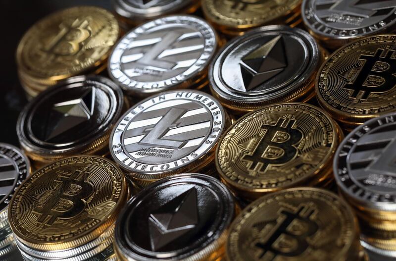 A collection of bitcoin, litecoin and ethereum tokens sit in this arranged photograph in Danbury, U.K., on Tuesday, Oct. 17, 2017. On Wednesday, billionaire Warren Buffett said on CNBC that most digital coins won't hold their value. Photographer: Chris Ratcliffe/Bloomberg