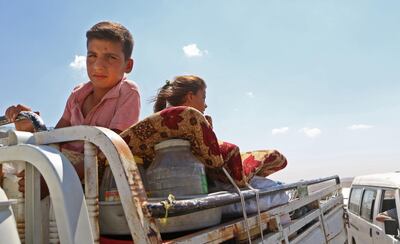 Syrians ride with their belongings in a pick up truck as they head to safer areas in the northern part of Syria's rebel-held Idlib province on September 6, 2018. - Hundreds of civilians have fled villages near the front line in Syria's Idlib province fearing an imminent regime assault on the country's last major rebel bastion, a monitor said. (Photo by Aaref WATAD / AFP)