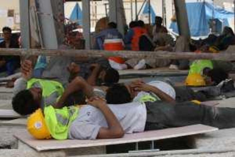 DUBAI - JULY 1,2009 - Workers  take advantage of the midday break by taking a nap  whle waiting for the start of their work in Dubai. The midday break was enforce to monitor and protect the health of construction workers. ( Paulo Vecina/The National )  *** Local Caption ***  PV break 1.jpg
