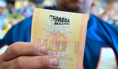 A man shows his just purchased lottery tickets from the Blue Bird Liquor store in Hawthorne, California on October 23, 2018 ahead of the drawing tonight for the Mega Millions jackpot, now reaching USD 1.6 billion.  / AFP / Frederic J. BROWN
