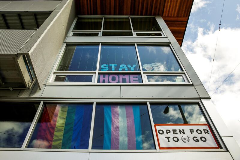 A sign that reads "stay home" is pictured above a take-out food sign in Seattle's Capitol Hill neighborhood. Reuters