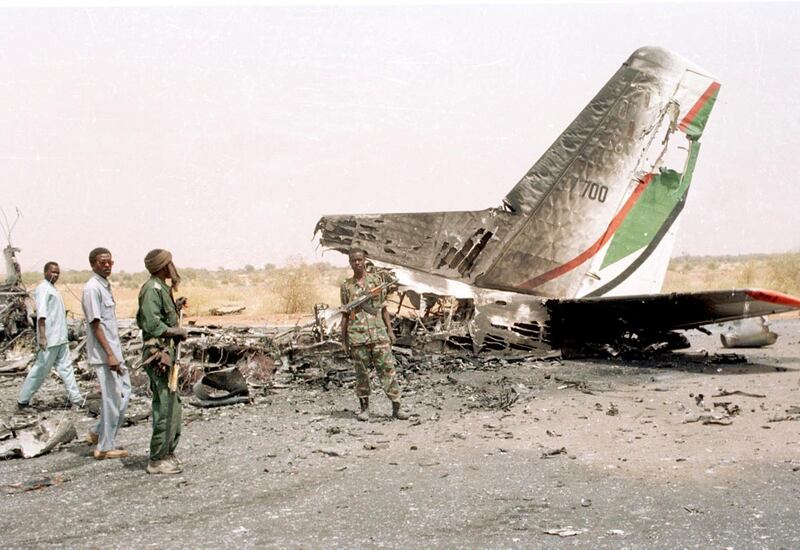 Sudanese soldiers look at a plane destroyed by the rebels on the North Darfur state capital of Al-Fasher 29 April 2003. Thousands of villagers have reportedly fled their villages since April 11 after fighting between government forces and the Sudan Liberation Army (SLA). Khartoum has refused to acknowledge any political motivation for unrest in the Darfur states, blaming it instead on "armed criminal gangs and outlaws," who it says are aided by tribes from neighboring Chad. AFP PHOTO/Salah OMAR (Photo by SALAH OMAR / AFP)