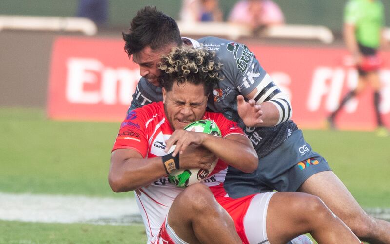 A Dubai Tigers player is tackled.