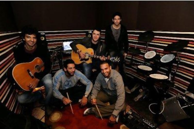 Members of the Cairo-based band Cairokee from left, in chairs, Sherif Hawary, Amir Eid, Sherif Mustafa, and from left on the floor, Tamer Hashem and Adam El Alfy in their studio at Eid's home in Maadi. Photos by Dana Smillie for The National