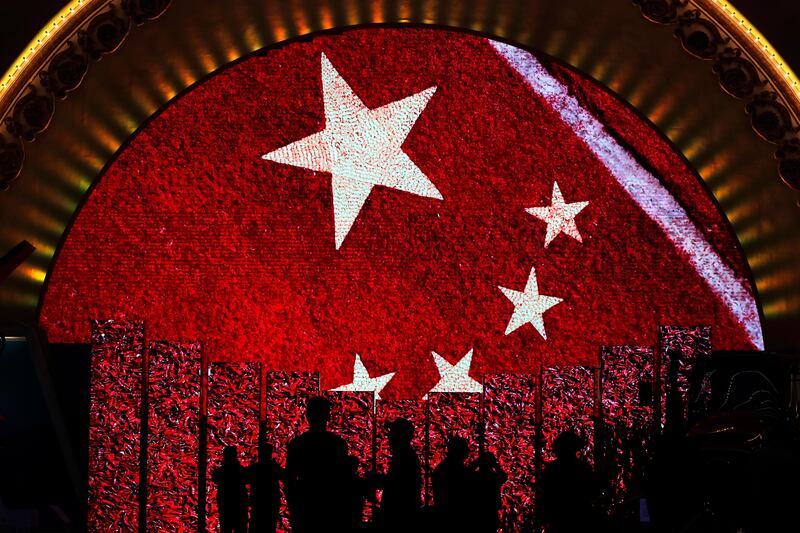Visitors watch video display boards showing the Chinese flag at an exhibition highlighting the country's achievements under five years of leadership by President Xi Jinping. Andy Wong / AP Photo