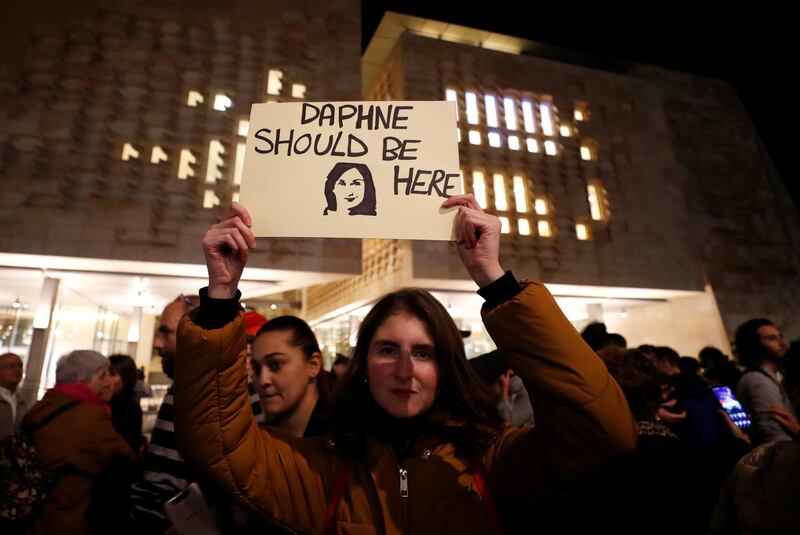 A demonstrator holds a sign during a protest outside the Parliament. Reuters