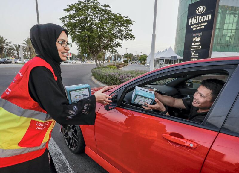 Abu Dhabi, United Arab Emirates, May 7, 2019.    Red Crescent volunteers and Abu Dhabi Police distribute food to motorists during iftar at the corner of 11th St. and 18th Sports City area.--  Hana Al Braeiki distributes food to motorists.
Victor Besa/The National
Section:  NA
Reporter:  Haneen Dajani
