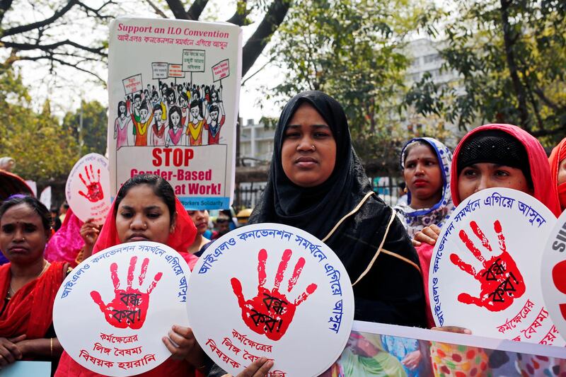 Activists from Bangladeshi women's organizations hold placards which read: 'stop gender based violence at the work place' as they participate in a International Women's Day march in Dhaka.  EPA