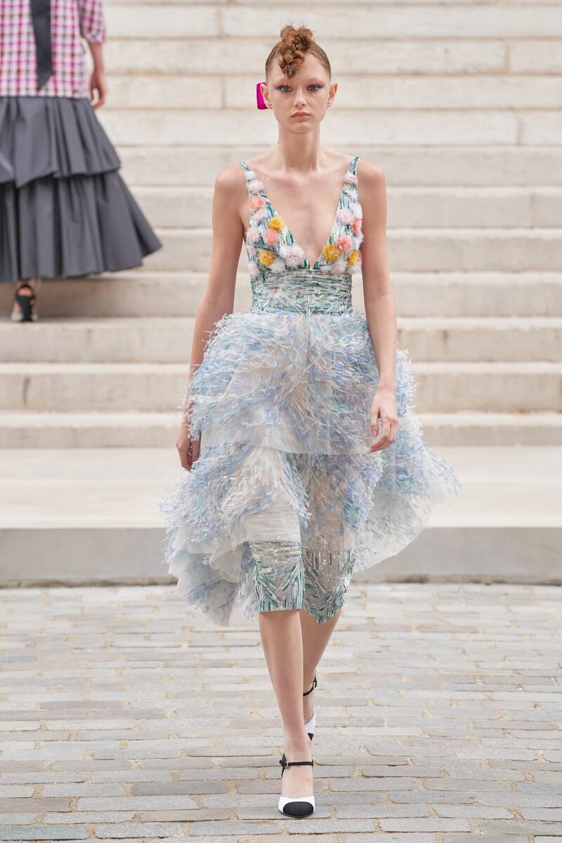 At Chanel, a tiered skirt was covered in feathers, while a halterneck top was decorated with lines of sequins and pom-poms.