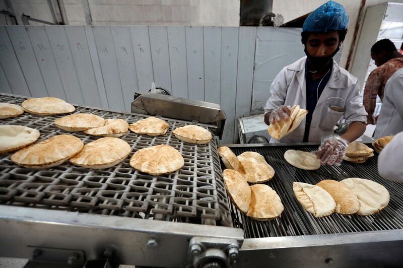 A Yemeni wearing a face mask and gloves works at a bakery amid the coronavirus pandemic in Sanaa, Yemen.  EPA