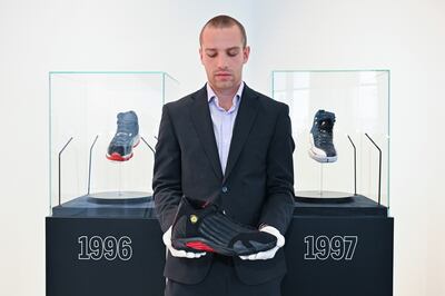 Eric Hirsch, Sotheby’s sports memorabilia specialist holding the 1998 Air Jordan XIV. Getty Images 