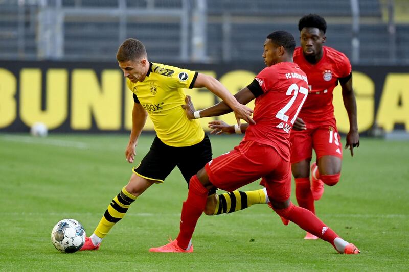 Bayern Munich's David Alaba and Alphonso Davies in action with Borussia Dortmund's Thorgan Hazard. Reuters