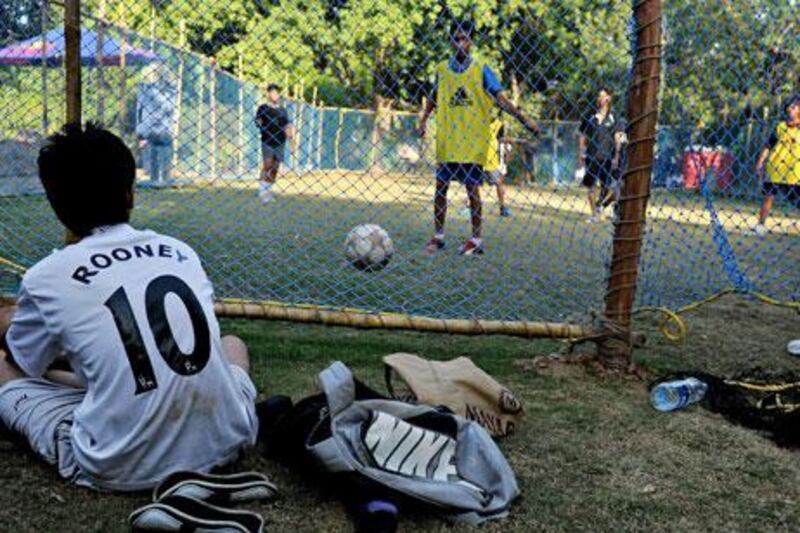 An Indian boy wearing a Manchester United shirt with Wayne Rooney’s name on the back watches a local street football game in New Delhi. Rooney and his United teammates are popular with Indian football fans and will be well supported in tomorrow’s Champions League final.