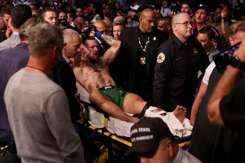 Conor McGregor is carried out on a stretcher after breaking his leg in the first round of his fight against Dustin Poirier during UFC 264 at the T-Mobile Arena in Las Vegas on Saturday, July 10.