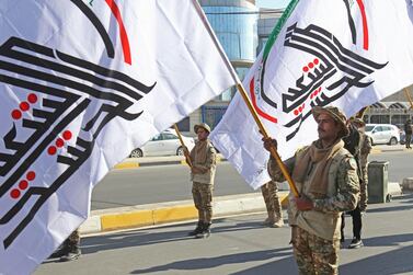 Members of the Hashed Al Shaabi, an Iraqi paramilitary network dominated by Iran-backed factions, wave the faction flag during a symbolic funeral ceremony in Iraq's central holy city of Karbala on December 29, 2020. AFP