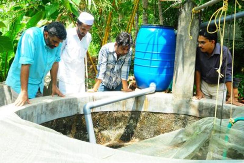 Volunteers from Miles, a village empowerment initiative started by a Dubai-based doctor check a rain water harvesting project that aims to help villagers of Kalpakanchery in southern India's Kerala state who suffer from water scarcity.

From left to right:  Irfan Habeeb, executive director of the Miles programme, Shafeeque Gazzali, Pratheek and Ashraf V.M. 

The rain water from the terrace of village homes passes through a plastic drum, which acts as a filter cleaning the water, and finally into a well. A nylon net is placed on top of the well to prevent leaves and other particles from entering.  The goal is to reach 500 homes by December and 40,000 people over 1-2 years. (Courtesy Miles) 