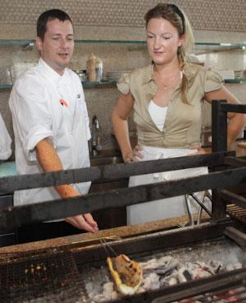 Sophia Money-Coutts watches the Zuma chef Colin Clague grilling sea-bass.