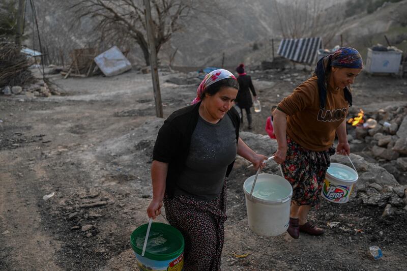 Women carry buckets of water in Yaylakonak village in Adiyaman, in Turkey. AFP