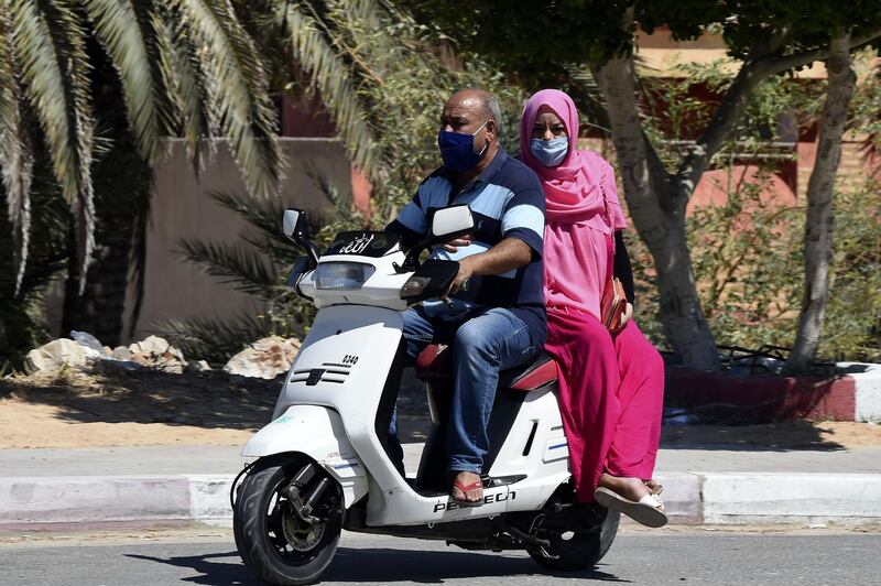 A man and a woman ride a scooter in the town of El-Hamma, in Tunisia's southwestern Gabes governorate, after a surge in the cases of infection there.  AFP