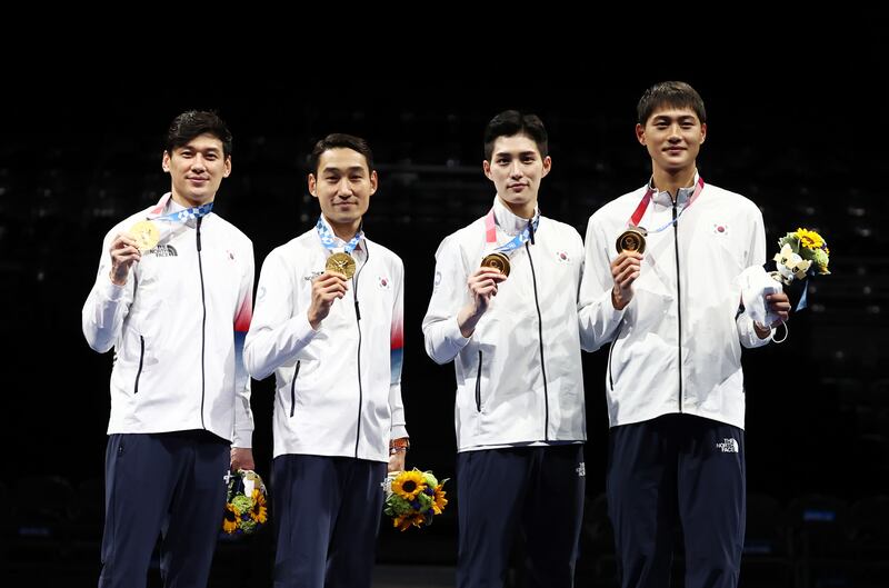 South Korean fencers Gu Bon-gil, Kim Jung-hwan, Kim Jun-ho and Oh Sang-uk pose after their victory over Italy in the final of the men's team sabre fencing event.