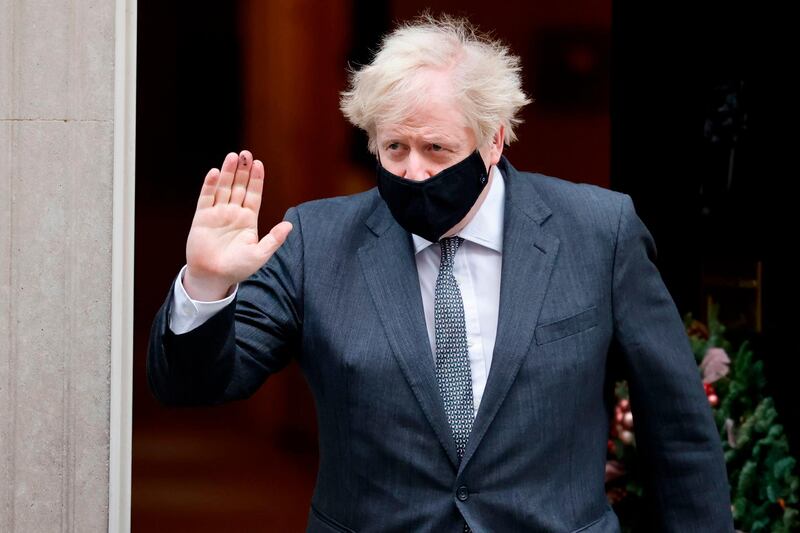 Britain's Prime Minister Boris Johnson wearing a protective face covering gestures as he leaves 10 Downing Street in London. AFP