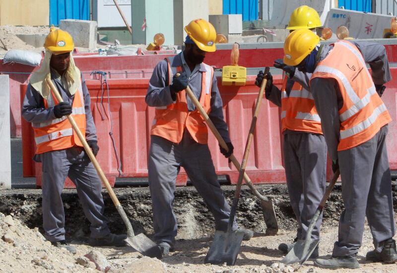 Workers are seen at a construction site in Doha, on November 16, 2014. Qatar, host of the 2022 football World Cup, pledged  to introduce new legislation to replace the controversial "kafala" sponsorship system and improve conditions for migrant workers by early 2015. The current law, which limits the rights of movement for foreign workers, would make way for legislation that was "currently under review," said the labour and social affairs ministry.  AFP PHOTO/STR / AFP PHOTO / -