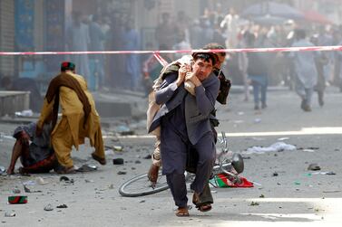 A man caries a wounded person to the hospital after one of several bombings in Jalalabad on August 19, 2019. Reuters