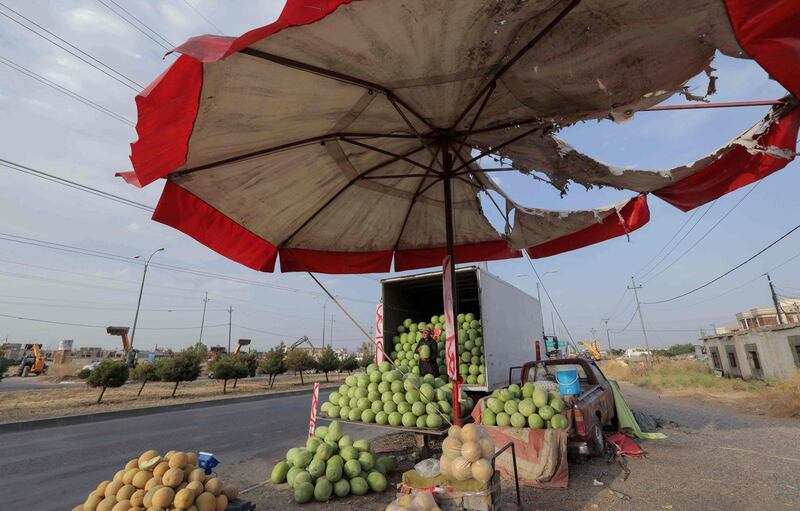 A Kurdish street vendor stacks fruit on the side of a road in Erbil, the capital of the autonomous Kurdish region of northern Iraq. AFP