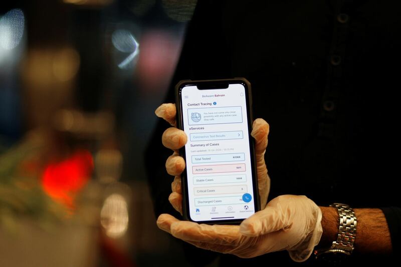 A man wearing protective gloves shows the interface of the app "Be Aware", launched by Bahrain's health authorities to contain the coronavirus disease, at a hotel in Manama, Bahrain. Reuters