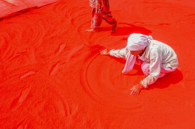 Workers spread red 'Gulal' coloured powder on the ground to prepare it ahead of Hindu 'Holi' festival, in Mathura on March 5, 2020. Holi, the popular Hindu spring festival of colours, is observed in India and across countries at the end of the winter season on the last full moon of the lunar month, which is March 8 this year. AFP