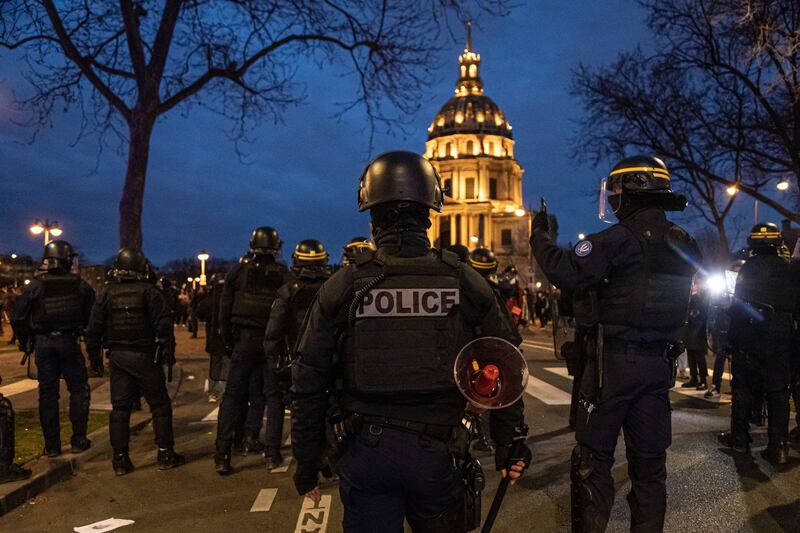 French riot police stand guard after clashes with protesters at Vauban Square in Paris on Monday night. EPA