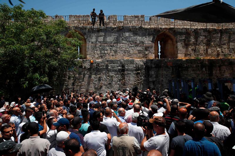 Palestinian Muslims, who refuse to enter due to new security measures including metal detectors and cameras, speak to the press outside the Lion's Gate, a main entrance to Al-Aqsa mosque compound, in Jerusalem's Old City, after security forces reopened the ultra-sensitive site.
Israel took the highly unusual decision to close the Al-Aqsa mosque compound for Friday prayers, leading to anger from Muslims and Jordan, the holy site's custodian. It remained closed on July 15, while parts of Jerusalem's Old City were also under lockdown. AFP